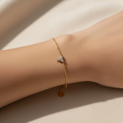 Model wearing a dainty 18k gold plated everyday chain bracelet on wrist under soft natural lighting.
